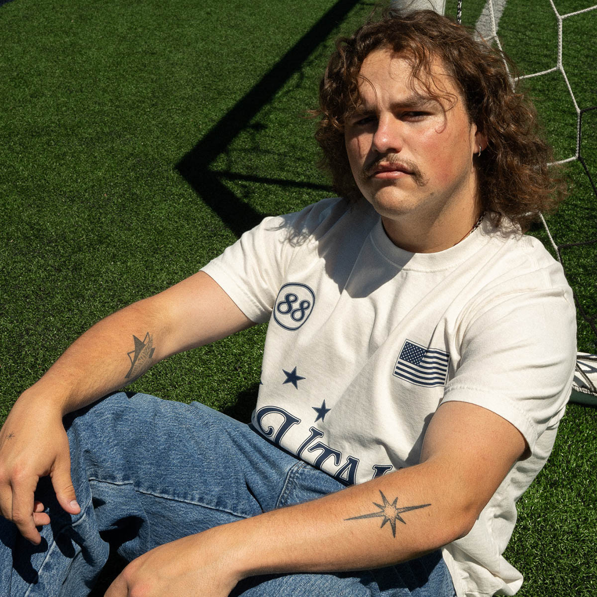 Young man wearing soccer jersey-inspired t-shirt on soccer field